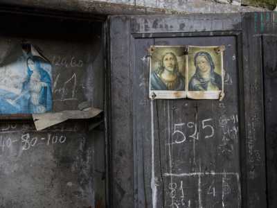 Un altro armadietto addobbato con figure sacre e santini